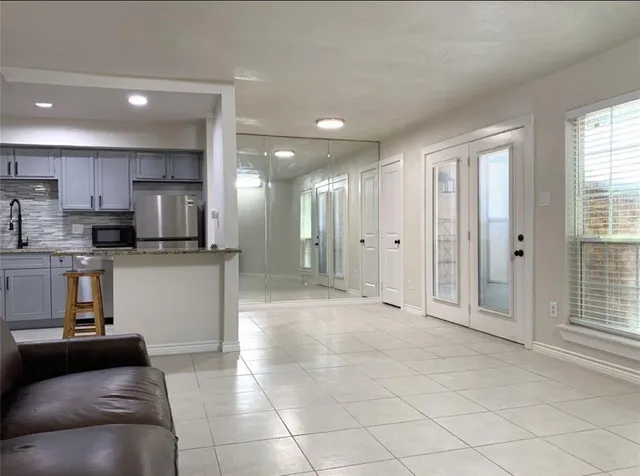 a view of a kitchen with a sink and dishwasher a refrigerator with white cabinets
