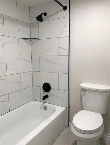 a white toilet sitting next to a bathtub
