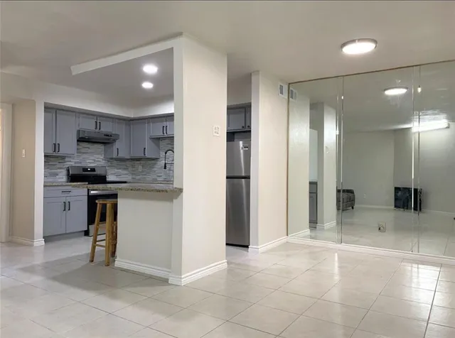 a kitchen with kitchen island granite countertop appliances cabinets and a sink
