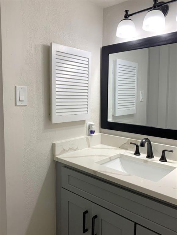 9803 Walnut Street, Unit 107 Dallas, TX 75243 - Photo 9 of 10 a bathroom with a sink and a mirror