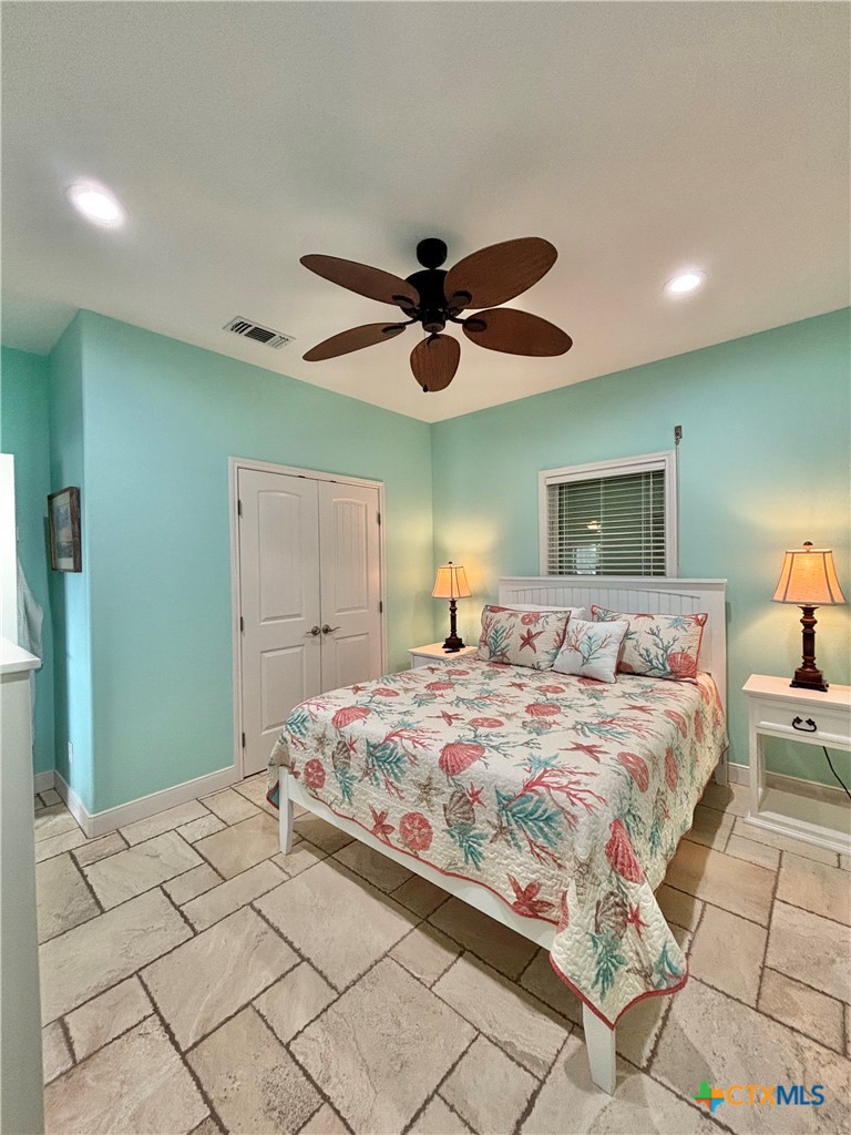 403 Maple Street Port O'Connor, TX 77982 - Photo 22 of 48 a bedroom with a bed and a ceiling fan