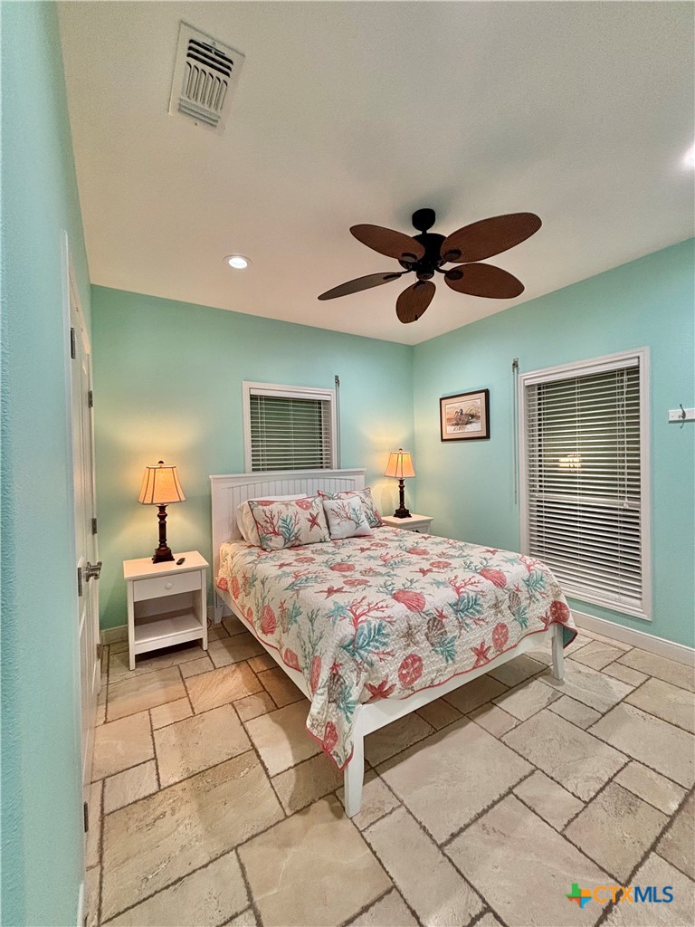 403 Maple Street Port O'Connor, TX 77982 - Photo 25 of 48 a bedroom with a bed and a chandelier