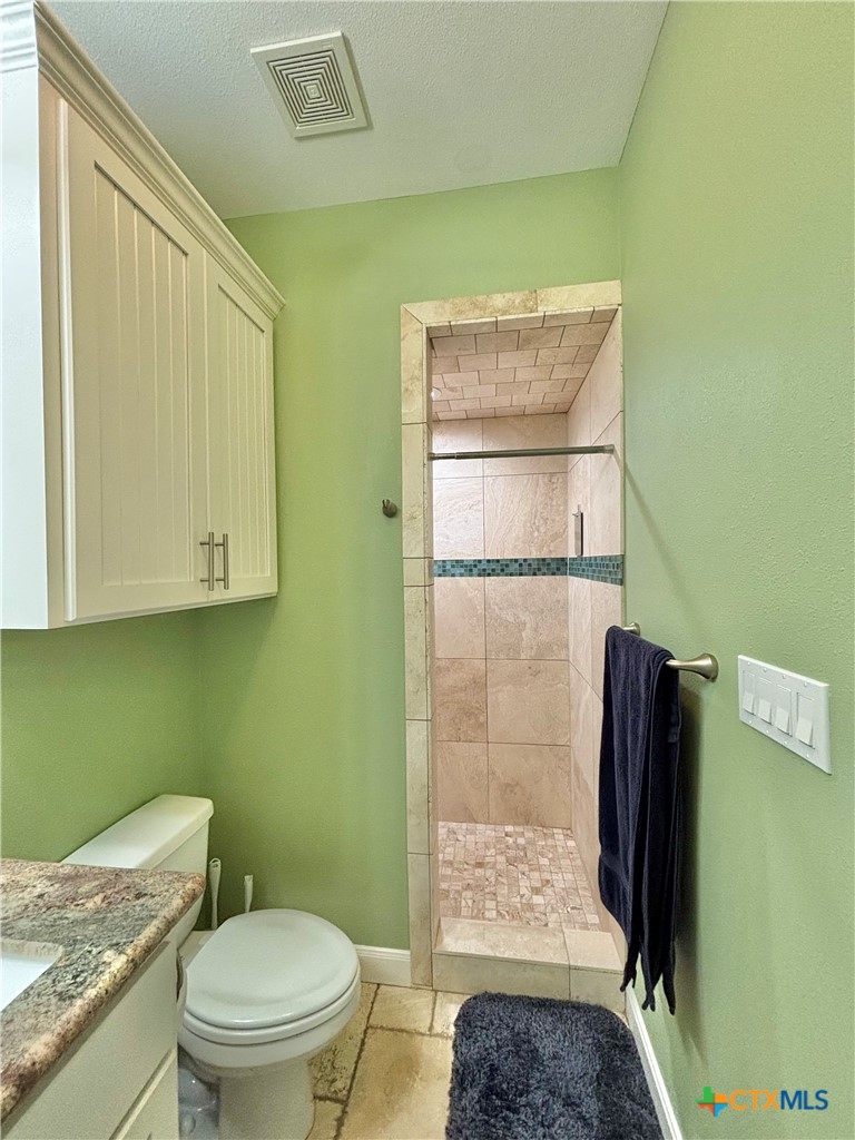 403 Maple Street Port O'Connor, TX 77982 - Photo 27 of 48 a bathroom with a granite countertop bathtub shower sink and toilet