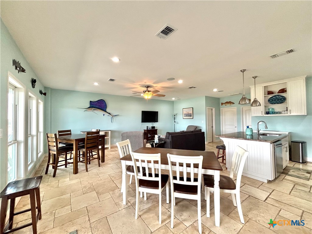 403 Maple Street Port O'Connor, TX 77982 - Photo 8 of 48 a dining area with stainless steel appliances kitchen island granite countertop a dining table chairs and a refrigerator
