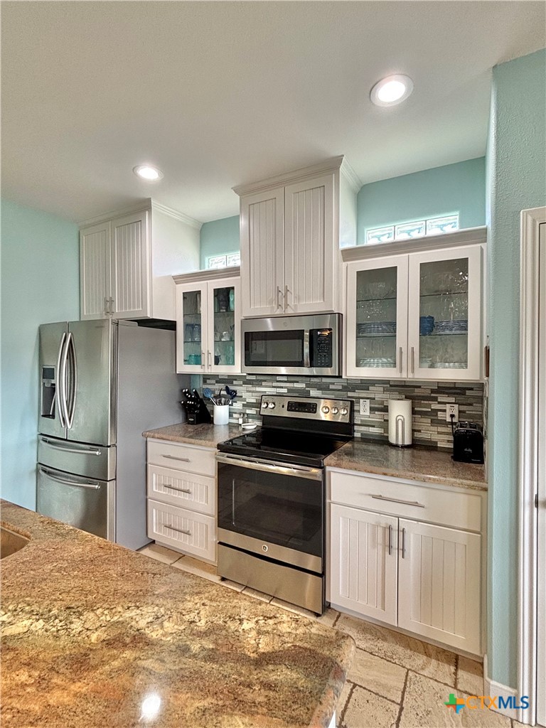 403 Maple Street Port O'Connor, TX 77982 - Photo 9 of 48 a kitchen with stainless steel appliances granite countertop a stove a refrigerator and a sink