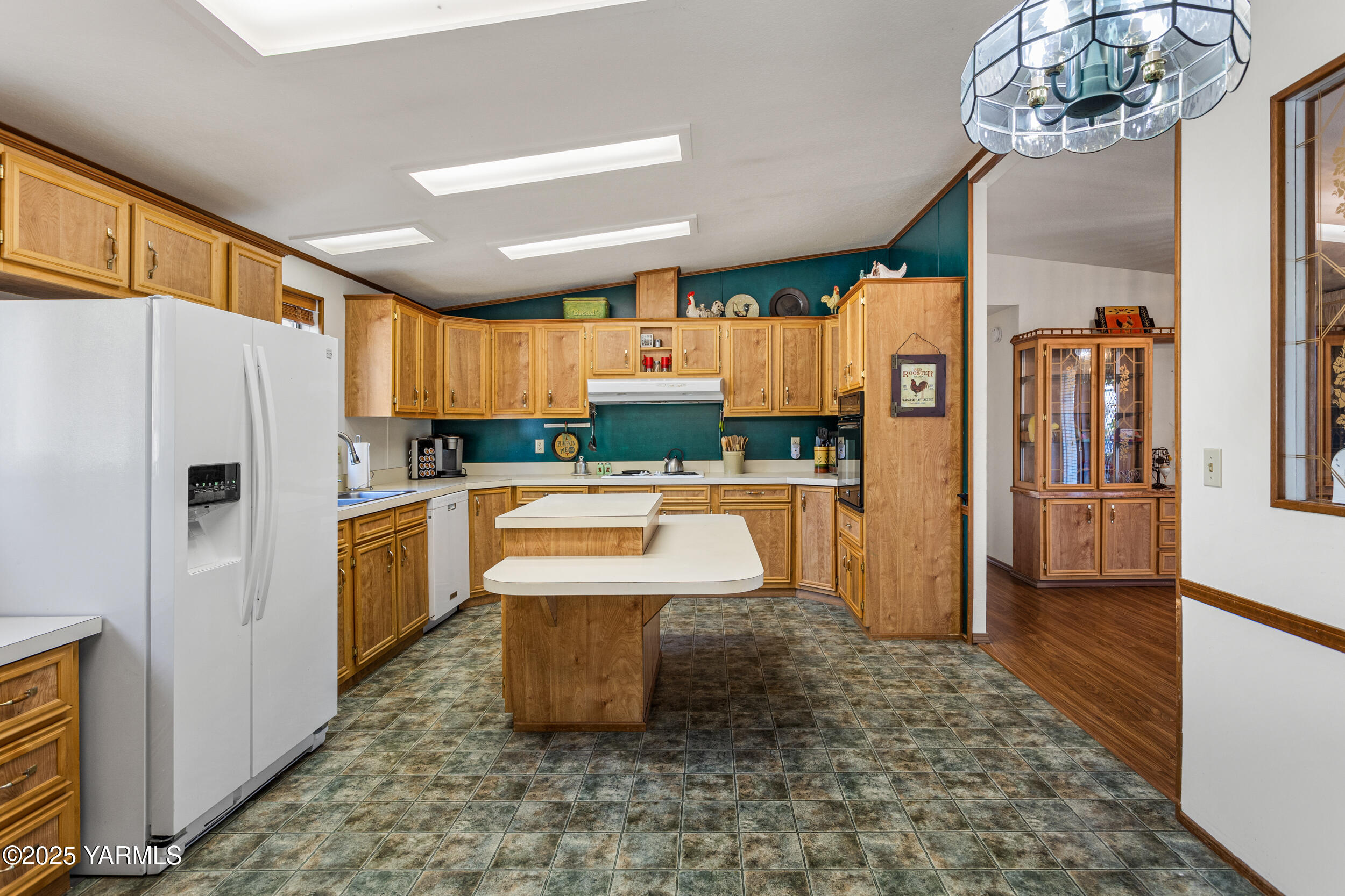 3701 Gun Club Road, Unit 64 Yakima, WA 98901 - Photo 8 of 30 a kitchen with stainless steel appliances kitchen island granite countertop a refrigerator a stove a sink a dining table and chairs with wooden floor