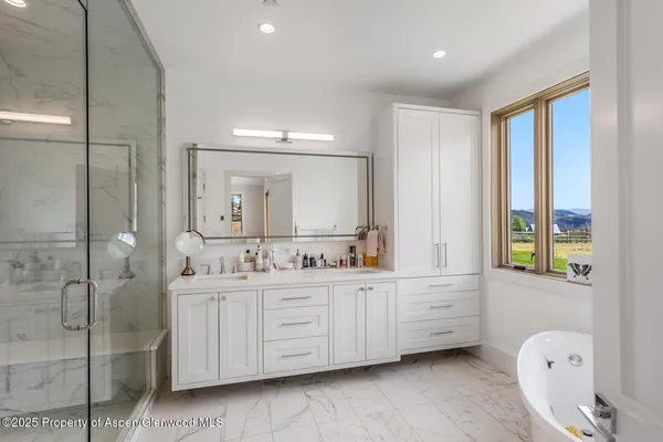 a bathroom with a double vanity sink a mirror and a bathtub