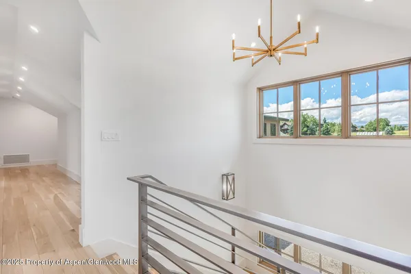 a view of a hallway with a window and a ceiling fan