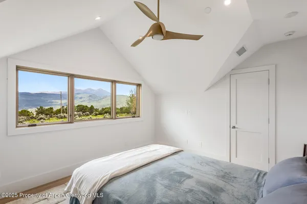 a bedroom with a bed and a large window