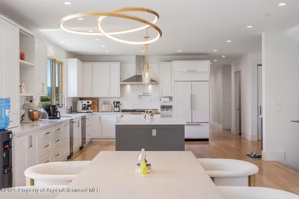 a living room with stainless steel appliances kitchen island granite countertop a refrigerator and a stove top oven