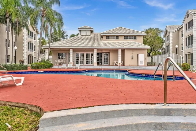 a front view of a house with a yard and potted plants