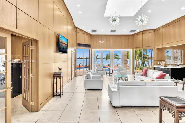 a dining hall with stainless steel appliances kitchen island granite countertop a table chairs and a view of living room