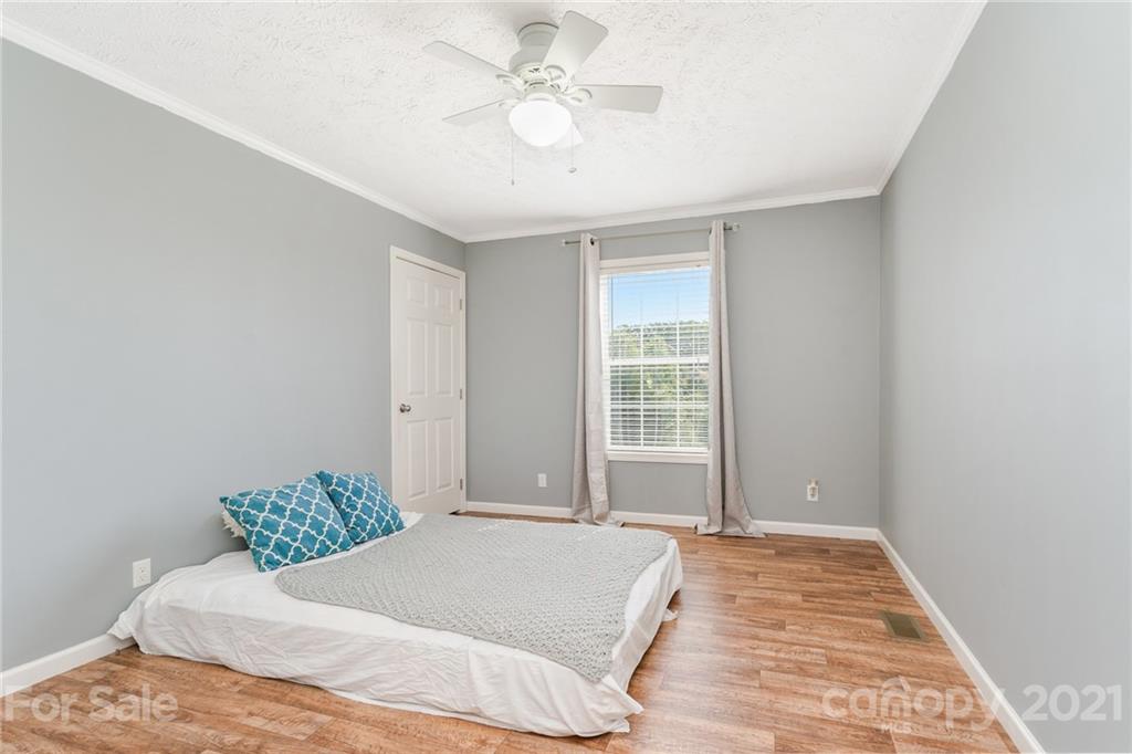 3782 Banoak Road Vale, NC 28168 - Photo 20 of 36 a bedroom with a large bed and a chandelier
