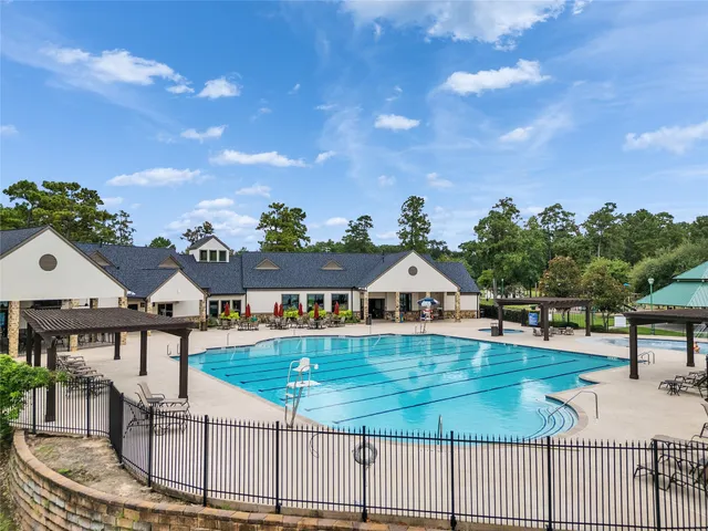 a swimming pool with outdoor seating and plants