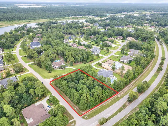 an aerial view of residential houses with outdoor space and trees