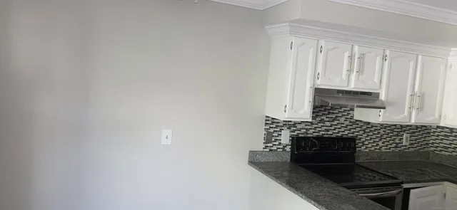 a kitchen with a refrigerator and a stove top oven