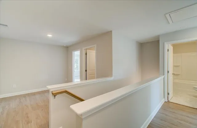 a view of an empty room with wooden floor