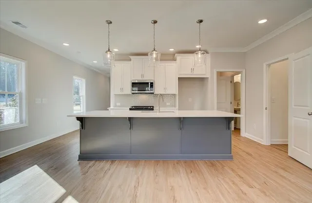 a kitchen with kitchen island white cabinets and refrigerator