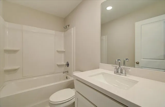 a bathroom with a sink toilet vanity and shower