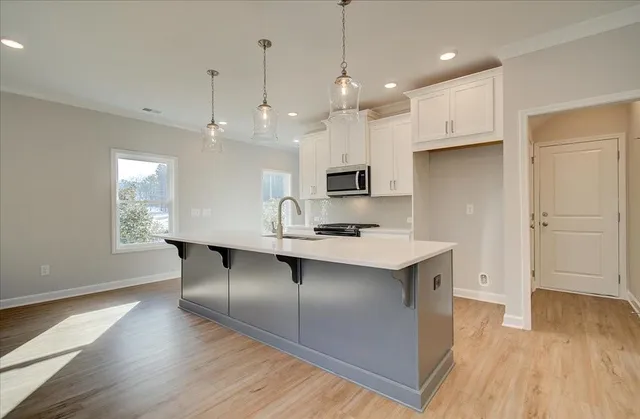 a kitchen with kitchen island a wooden floor and white appliances