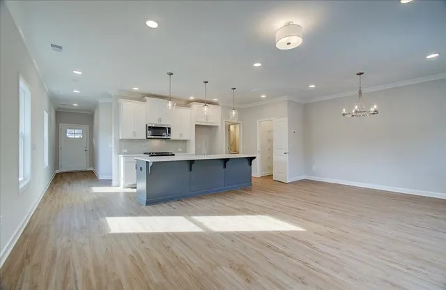 a large kitchen with stainless steel appliances kitchen island a large counter top and a wooden floors