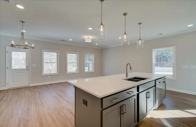 a kitchen that has a kitchen island hardwood floor sink stove and wooden floor