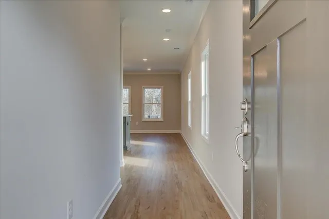 a view of a hallway with wooden floor and staircase