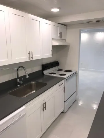 a kitchen with granite countertop a sink and cabinets
