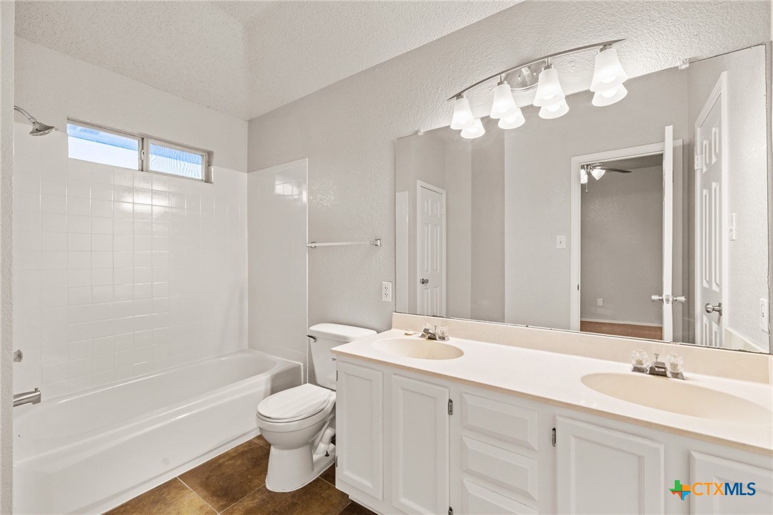 4215 Rifle Drive Killeen, TX 76542 - Photo 17 of 30 a bathroom with a double vanity sink mirror double toilet and bathtub