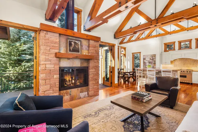 a living room with furniture a large window and a potted plant