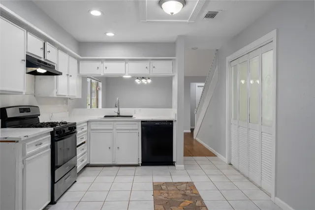 a kitchen with stainless steel appliances granite countertop a refrigerator and a stove