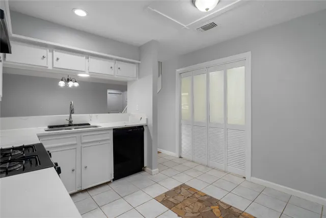 a large white kitchen with a sink and cabinets