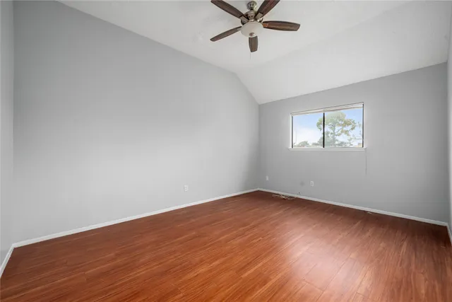 wooden floor in an empty room with a ceiling fan
