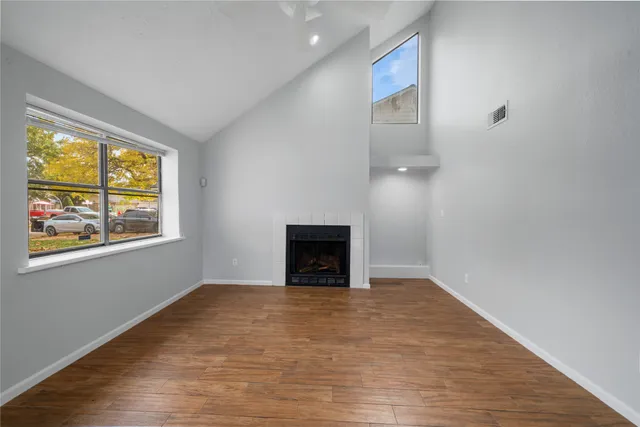 a view of an empty room with a window and fireplace