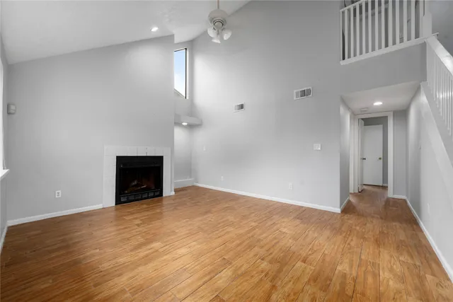 a view of empty room with wooden floor and fireplace