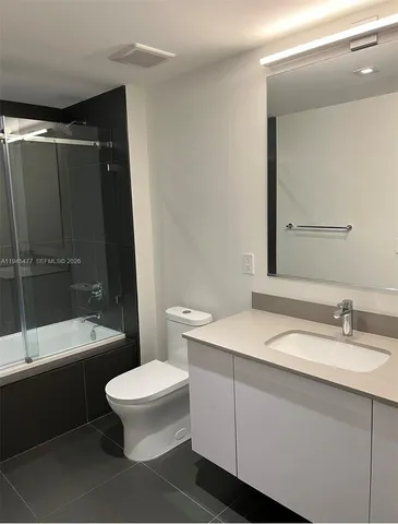 a bathroom with a sink toilet and shower