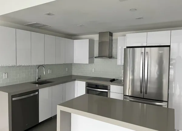 a kitchen with granite countertop a refrigerator and a sink