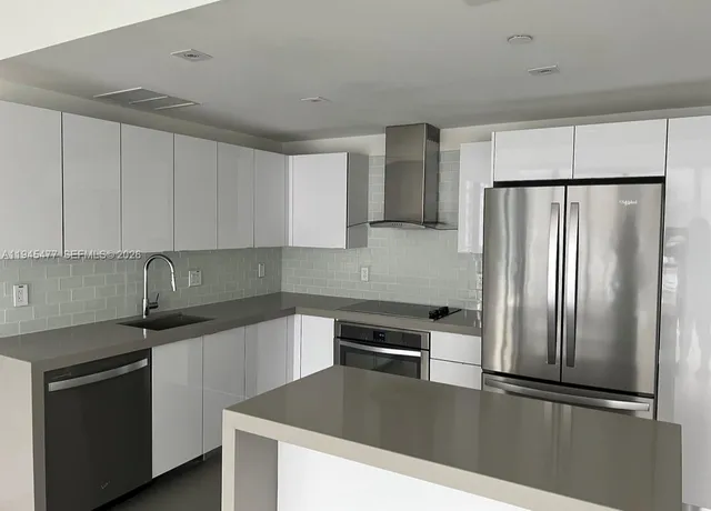 a kitchen with granite countertop a refrigerator and a sink