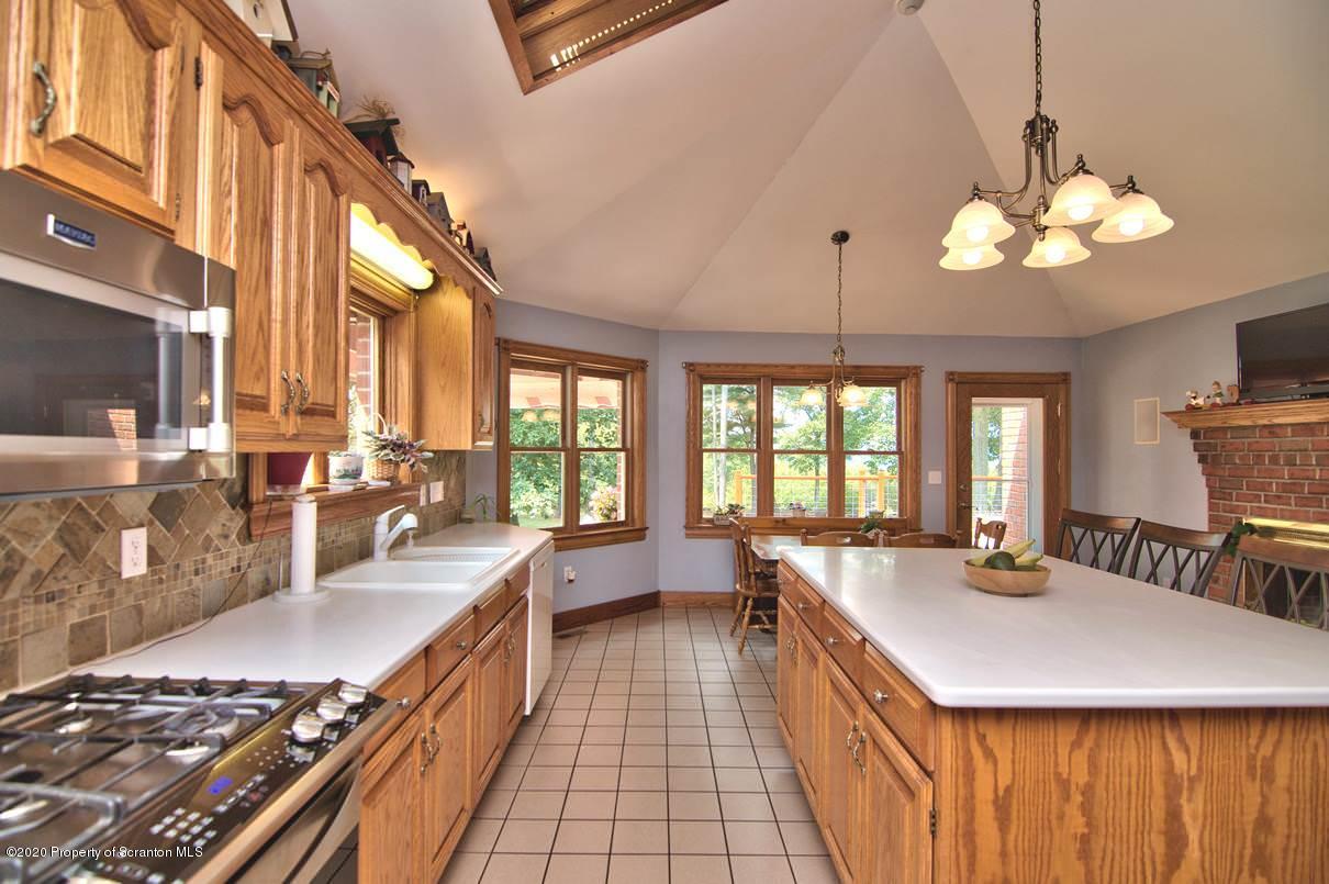 353 Ridge Road Wyoming, PA 18644 - Photo 31 of 157 a large kitchen with stainless steel appliances granite countertop a stove a sink dishwasher a dining table and chairs with wooden floor