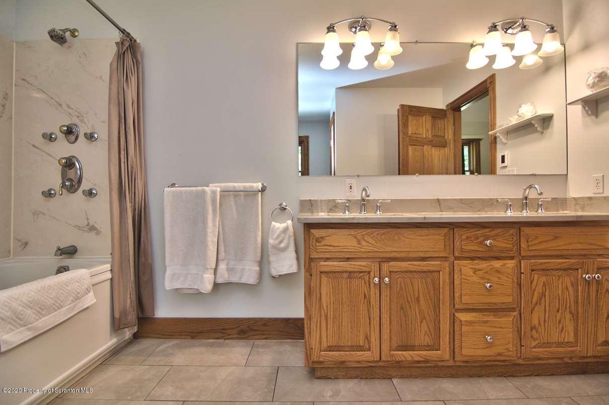 353 Ridge Road Wyoming, PA 18644 - Photo 39 of 157 a bathroom with a granite countertop sink a mirror and a bathtub