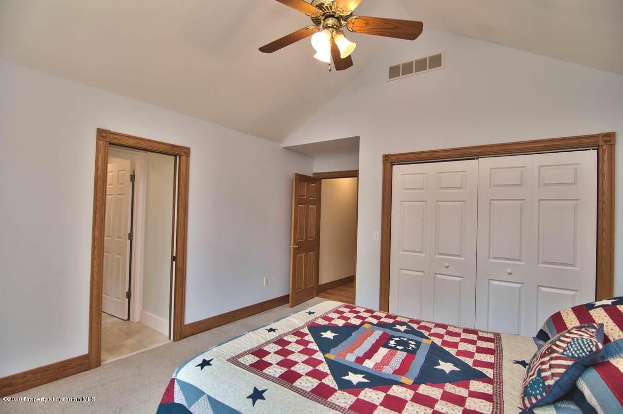 353 Ridge Road Wyoming, PA 18644 - Photo 48 of 157 a bedroom with a bed and a chandelier