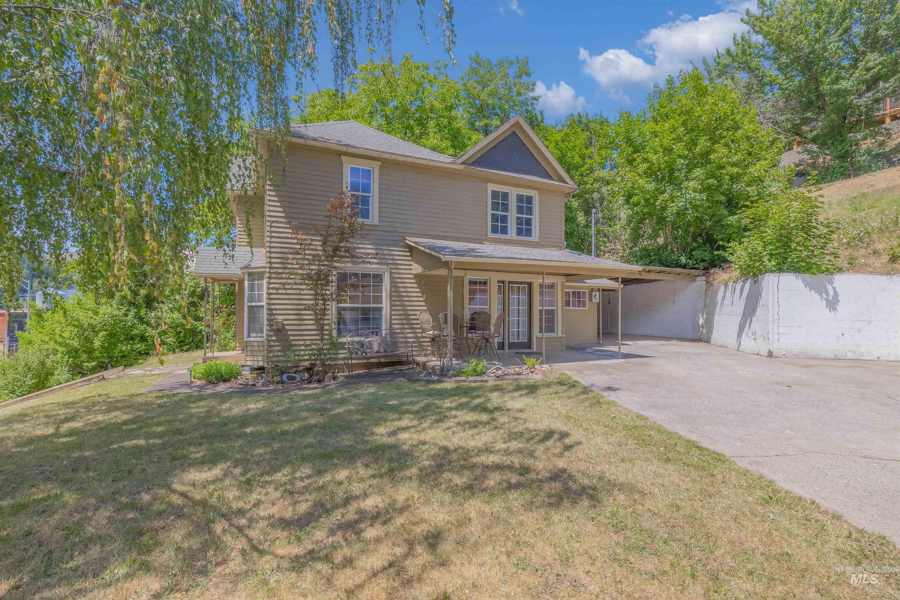 Traditional-style home featuring concrete driveway, patio area and attached carport