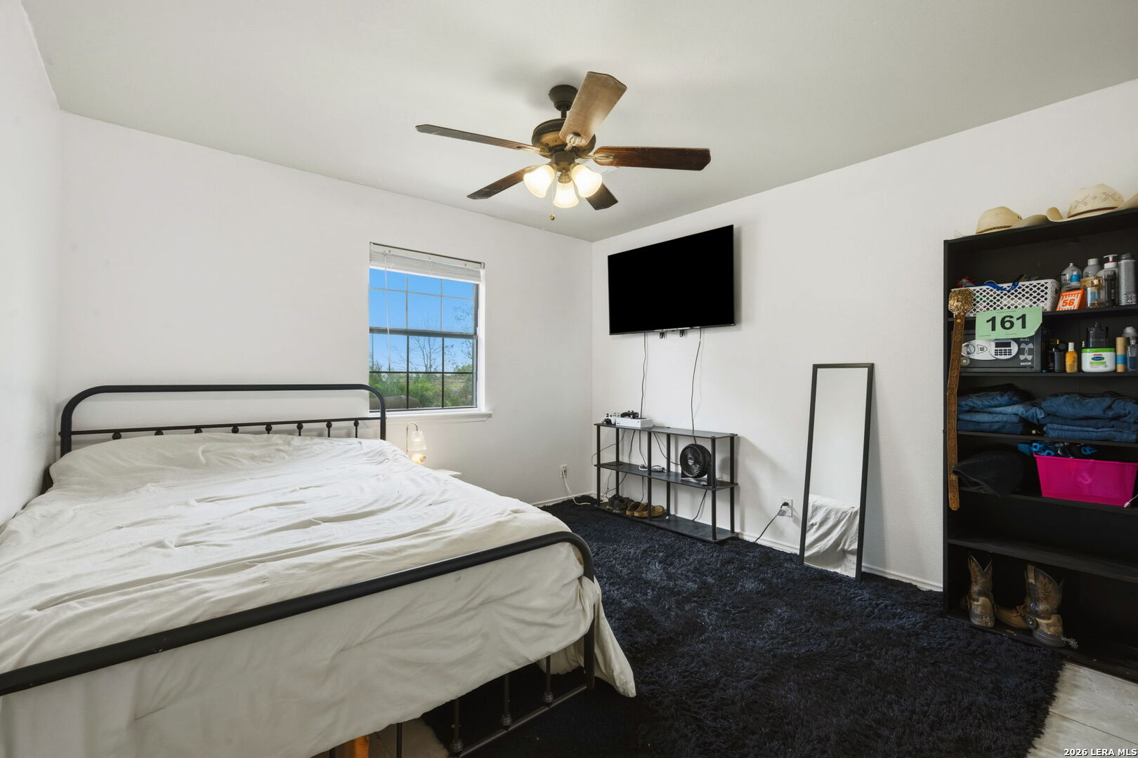 202 Bryan Drive Jourdanton, TX 78026 - Photo 18 of 28 a bedroom with a bed a flat screen tv and a chandelier