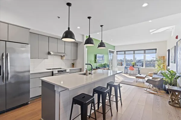 a kitchen with stainless steel appliances a dining table chairs stove and refrigerator