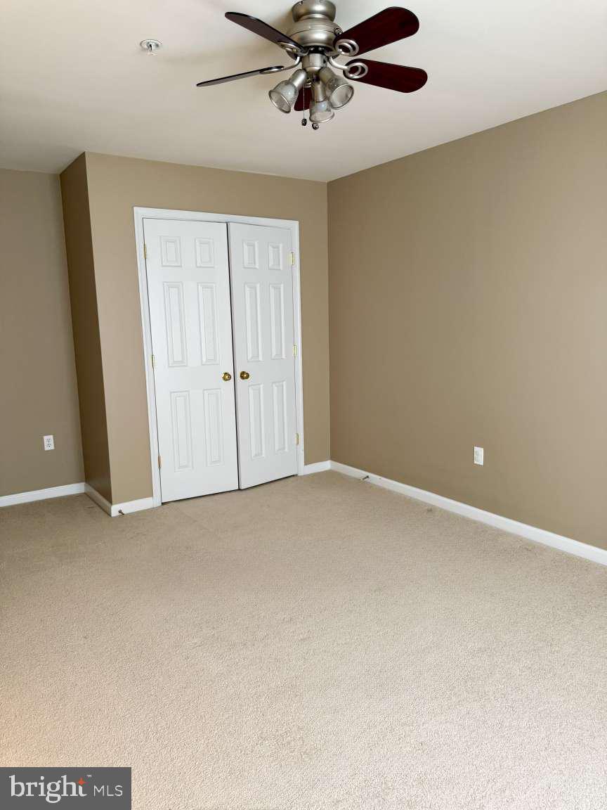 629 Ruxton Road, Unit 74 Solomons, MD 20629 - Photo 21 of 24 an empty room with a ceiling fan
