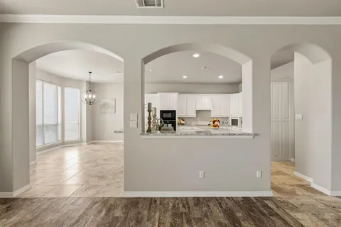 a view of kitchen with stainless steel appliances granite countertop cabinets and wooden floor