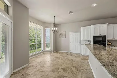 a view of a kitchen with granite countertop cabinets stainless steel appliances and a window
