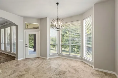 a view of an empty room with glass door and balcony