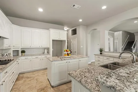 a kitchen with a sink a stove and cabinets