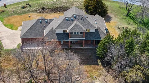 an aerial view of a house with a yard and large trees